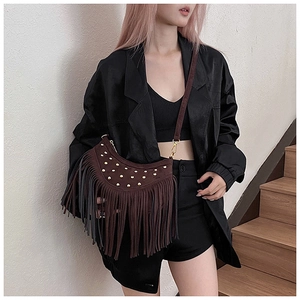Detail view of deep brown suede crossbody bag with vintage rivets and long fringe