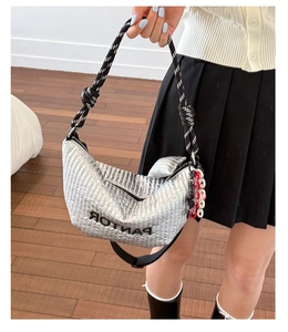 Close-up of silver quilted hobo bag with knotted black and white rope handle detail