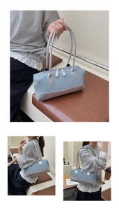 Detail of light blue denim Boston bag with silver PU metallic trim and twin zipper closure