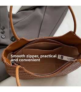 Vue intérieure du sac cabas tressé marron montrant la poche zippée et la doublure