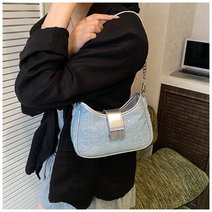 Detail of light blue denim bag with sparkling rhinestones and silver chain strap