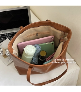Spacious interior of brown faux leather tote bag showing high capacity for essentials