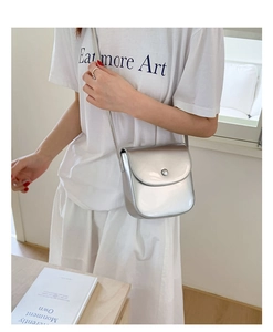 Détail du sac de selle argenté brillant avec finition métallique et fermeture magnétique