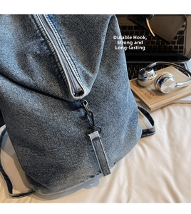Vue détaillée du crochet métallique robuste et de la fermeture éclair sur le sac en jean