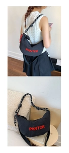Detail of black quilted crescent bag with red PANTOR embroidery and rope strap