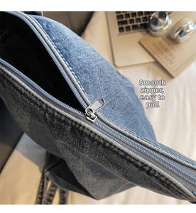 Gros plan sur la fermeture éclair argentée fluide d'un sac cabas en jean bleu