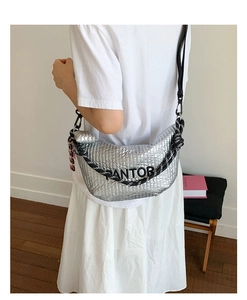 Fashionable silver metallic crossbody bag with woven shoulder strap shown in lifestyle shot