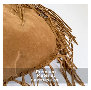 Detail of premium brown suede bag featuring bohemian fringe craftsmanship and texture