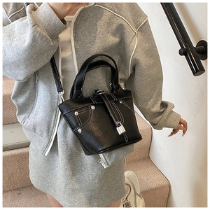 Détails du sac seau noir grainé avec surpiqûres blanches contrastées et rivets métalliques