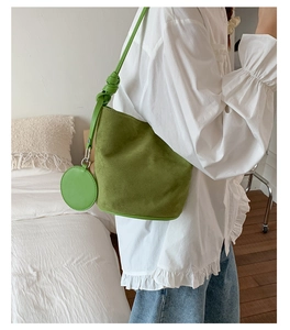 Avocado green bucket bag with a matte finish and matching round coin purse detail