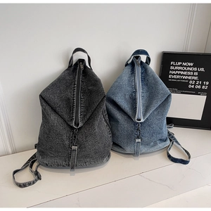 Détail de sacs à dos en denim délavé vintage avec fermetures éclair et poignées