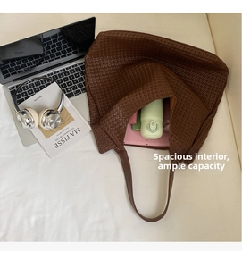 Detail view of woven leather tote bag texture and large interior storage capacity