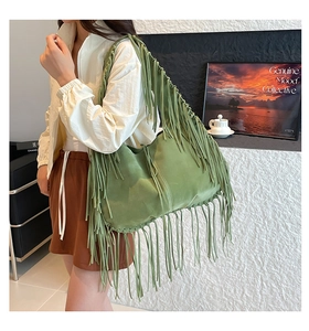 Detailed macro view of olive green suede hobo bag with long bohemian fringes