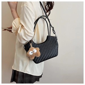 Vue détaillée du sac cabas tressé noir avec bandoulière et accessoire en étoile