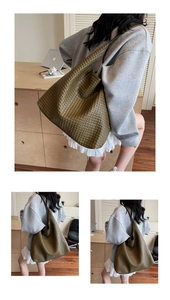 Detailed view of dark olive green woven leather tote bag with artisanal hobo texture
