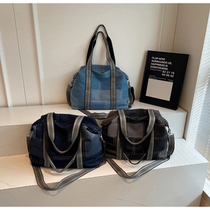 Detailed shot of three denim tote bags in light blue, dark blue, and black with contrast stitching