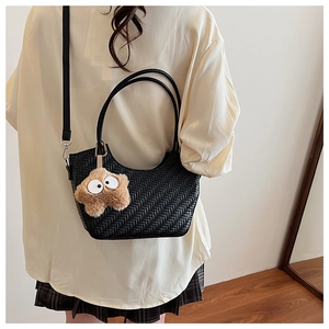Détail du sac à bandoulière noir tressé avec pendentif étoile et sangle ajustable