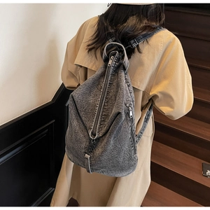 Gros plan du sac à dos en jean gris délavé vintage avec fermeture éclair verticale