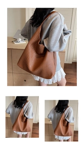 Detail of the woven texture and soft shoulder strap on the brown hobo tote bag