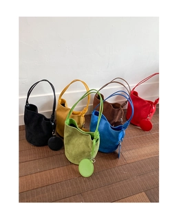 Detail of colorful suede bucket bags with matching round coin purses and knotted straps