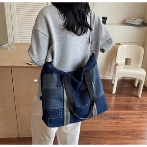 Detail shot of the large denim patchwork tote bag with contrast stitching and sturdy handle
