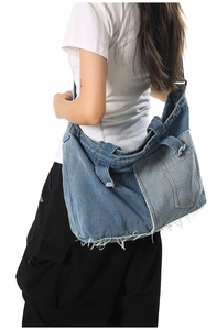 Close-up of patchwork denim crossbody bag with frayed edges and wide shoulder strap