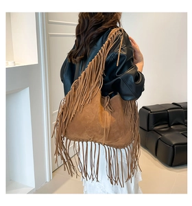 Detail of vintage brown suede hobo bag featuring long tassels and bohemian fringe style