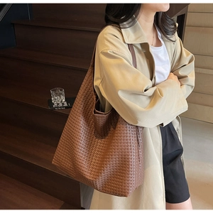 Close-up of brown woven leather texture on a large capacity vintage hobo shoulder bag
