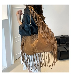 Detail of bohemian caramel suede tote bag featuring long flowing fringe and shoulder straps