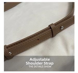 Détail de la bandoulière réglable en cuir grainé marron foncé avec clous en métal
