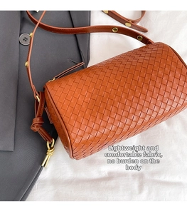 Close-up of brown woven leather texture on a vintage Boston bag with gold buckle