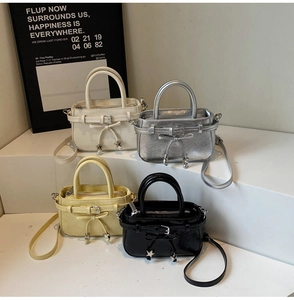 Macro display of four small square handbags in cream, silver, yellow, and black colors