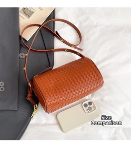 Detailed view of caramel woven leather Boston bag with size comparison to a phone