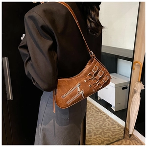 Detail of a brown rock-style underarm bag featuring silver zippers and metallic buckles