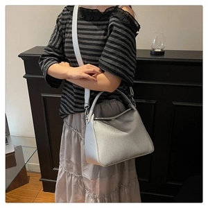 Detailed view of silver lychee texture leather handbag with adjustable shoulder strap