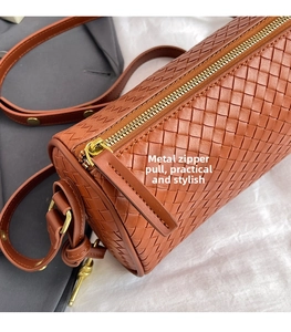 Detail of premium brown woven leather texture with high-quality golden hardware zipper