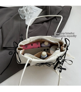 Top view showing spacious interior with zipper pocket of white tote bag and bow detail