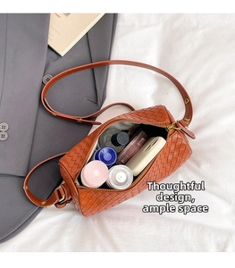 Detail view of woven brown boston bag interior showing spacious room for cosmetics