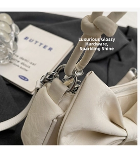 Detailed macro view of silver hardware and bow knot decoration on a white shoulder bag