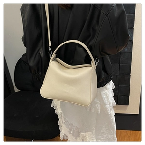 Detail of soft cream pebbled leather handbag with silver hardware and shoulder strap
