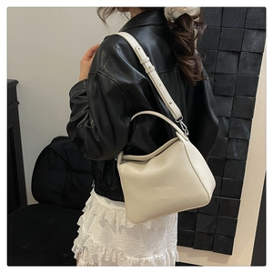 Sac bandoulière en cuir grainé sur modèle avec bandoulière réglable et poignée fixe
