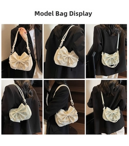 Detail view of beige bow shoulder bag with pearl chain strap worn by a model