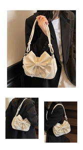 Detail of white PU leather bag featuring a large bow and pearl flower chain strap