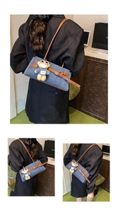 Detail of denim patchwork tote with brown leather straps and cute plush bear charm