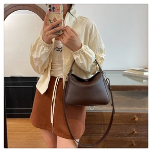 Detail of dark brown lychee grain leather handbag with adjustable shoulder strap