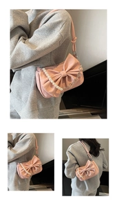 Detailed view of pink shoulder bag featuring a large bow and pearl heart metal chain