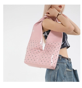 Detail of pink patent leather hobo bag with silver metal studs in Y2K style