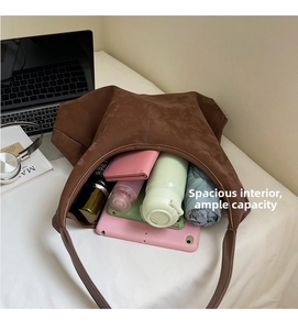 Spacious interior of brown suede tote bag showing tablet, umbrella and wallet storage