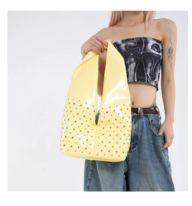 Detailansicht der gelben Lackleder-Hobo-Tasche mit silbernen Nieten und Applikationen