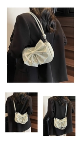 Detail of mint green shoulder bag featuring a large bow and pearl flower chain strap
